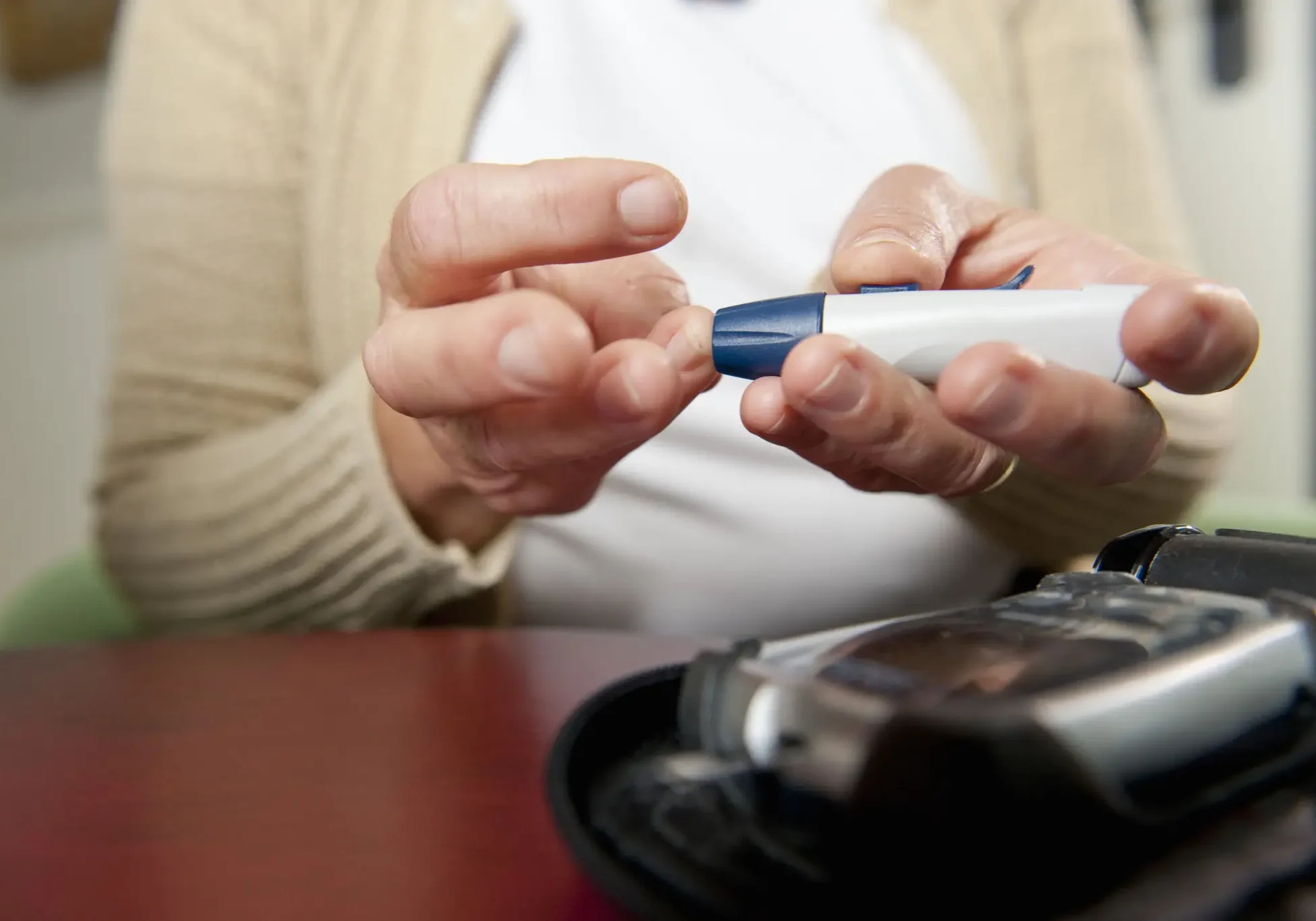 Hands performing blood glucose test with glucometer