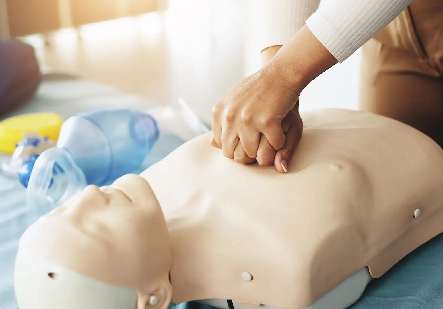 Person performing CPR chest compressions on manikin